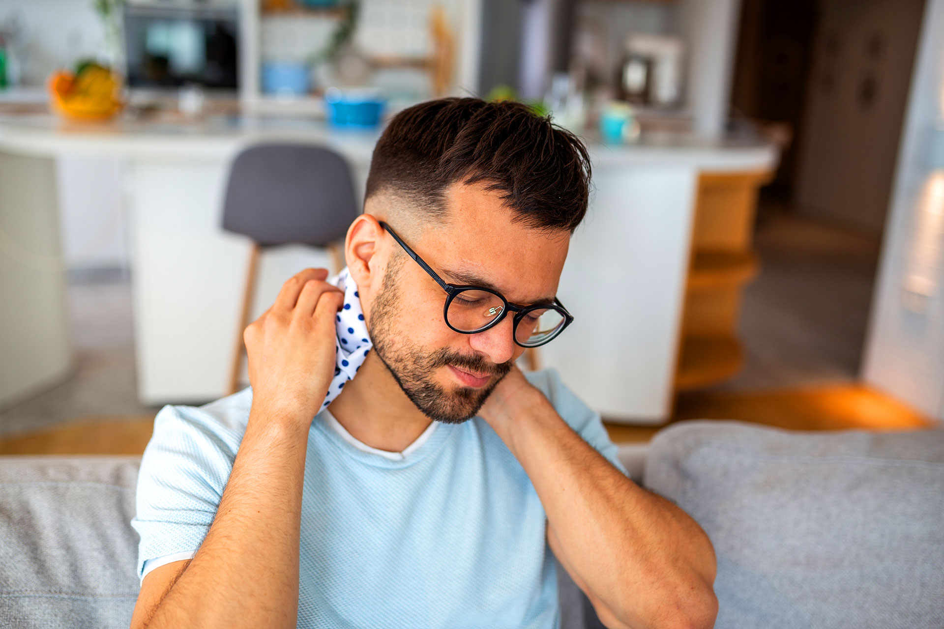 Person holding the back of their neck due to pain and stiffness