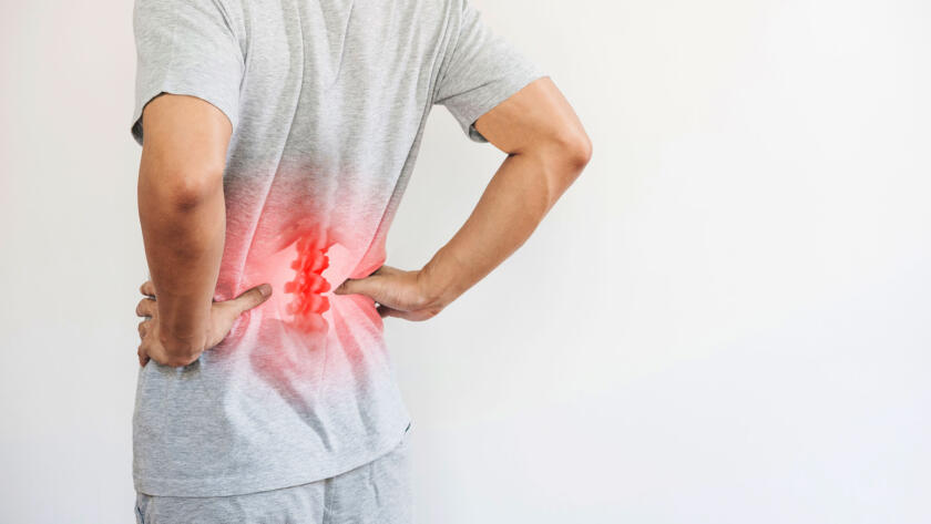 Man holding his lower back with highlighted spine indicating chronic back pain