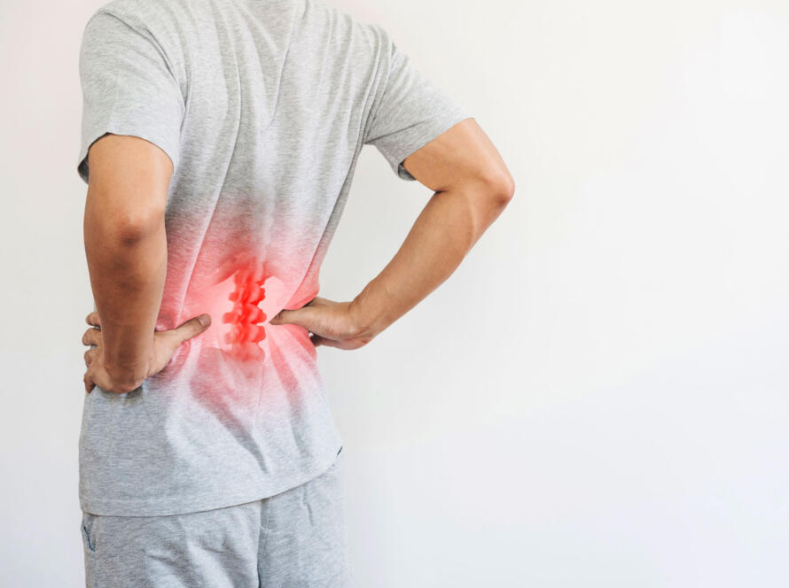 Man holding his lower back with highlighted spine indicating chronic back pain