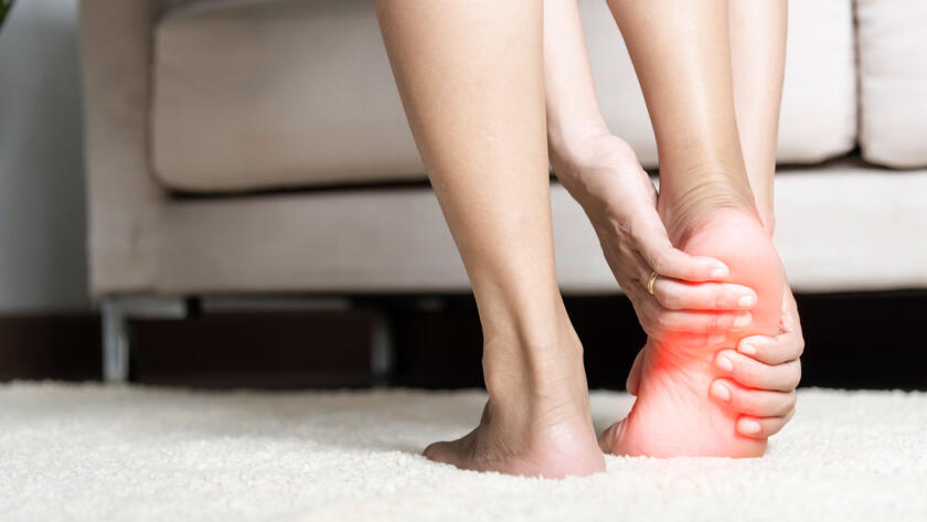 Woman gripping her painful ankle with red inflammation highlight on the joint