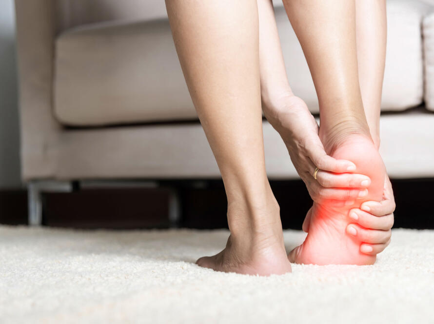 Woman gripping her painful ankle with red inflammation highlight on the joint