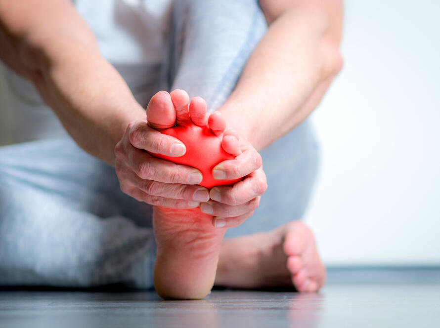 Person massaging foot with red pain highlight overlay